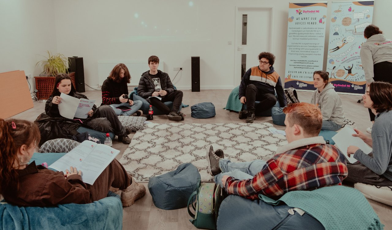 young people sat in a circle discussing ideas - Safe Space to Speak - Dyfoldol Ni